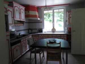 a kitchen with red and white cabinets and a table at 1 Chambre d hôtes dans un écrin de verdure in Dambach