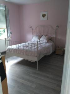 a bedroom with a bed in a pink room at 1 Chambre d hôtes dans un écrin de verdure in Dambach