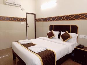 a hotel room with a large bed with towels on it at Villa La Grande A Couple Friendly Property Near New Bus Stand in Pondicherry +8 photos