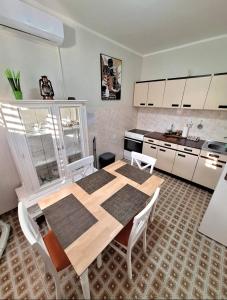 a kitchen with a wooden table and white cabinets at Red House Apartment in Kotor