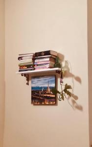 a picture hanging on a wall with a pile of books at Casa Torino Lingotto centro fiere, metro, Inalpi Arena,Centro Congressi, Ospedale Molinette, Politecnico in Turin