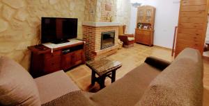 a living room with a couch and a fireplace at Alameda II con CHIMENEA Salòn y BARBACOA en patio in Curiel de Duero