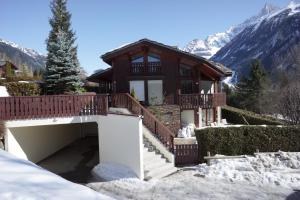 une maison avec un balcon et des escaliers dans la neige dans l'établissement Chamonix Balcons du Mont Blanc, à Chamonix-Mont-Blanc