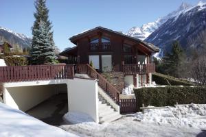 ein Haus mit einem Balkon und einer Treppe im Schnee in der Unterkunft Chamonix Balcons du Mont Blanc in Chamonix-Mont-Blanc