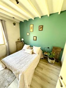 a bedroom with a bed and a green wall at Cocon en Provence à Ménerbes in Ménerbes