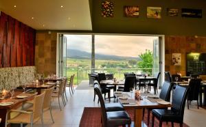 ein Restaurant mit Tischen und Stühlen und einem großen Fenster in der Unterkunft Val Du Charron Wine & Leisure Estate in Wellington