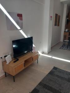 a living room with a flat screen tv on a table at loft ΑLEXIA in Pyrgos