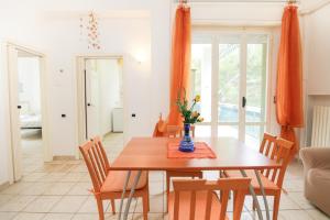 a dining room with a wooden table and chairs at Casa Vacanze Marcelli51 - Soggiorni Le Grotte in Marcelli +14 photos