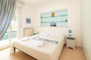a white bedroom with a bed and a window at Casa Vacanze Marcelli51 - Soggiorni Le Grotte in Marcelli
