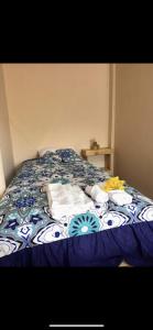 a bed with a blue comforter with towels on it at Raimy Sumaq in Arenillas +6 photos