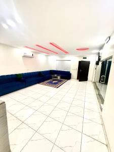a living room with a blue couch and a white tile floor at شاليهات زارا Zara in Taif +2 photos