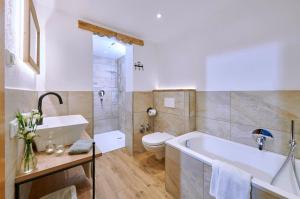 a bathroom with a tub and a toilet and a sink at Bauernhof Berndlhof Obing in Obing +14 photos