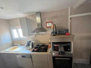 a small kitchen with a stove and a sink at Maison de Nathony in Maisons-en-Champagne