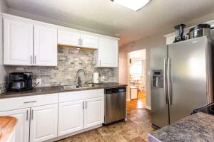 a kitchen with white cabinets and a stainless steel refrigerator at Copper Voyage, Fenced Backyard in Coeur d'Alene