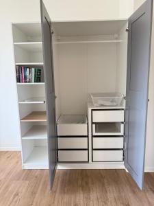 a white closet with white doors and shelves at Kaiserlich schlafen in der alten Post in Oelsnitz