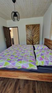 a bedroom with a large bed with a wooden headboard at Apartmány U GUNÁRA Vyhne - Apartmán Akácia in Vyhne