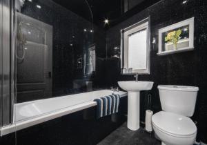 a black bathroom with a toilet and a sink at Rothesay House by Klass Living Coatbridge in Coatbridge +24 photos