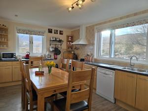 a kitchen with a wooden table and a dining room at Little Loch View in Durnamuck +21 photos