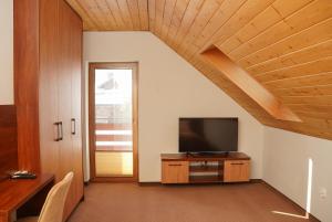 a living room with a television on a wooden cabinet at Urocze Wysowa in Wysowa-Zdrój