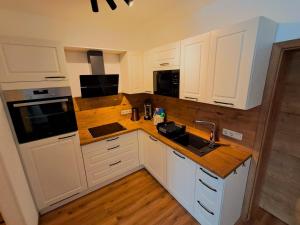 a kitchen with white cabinets and a sink at Pension Kronenburghof in Erfurt