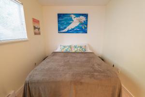 a bed in a room with a painting on the wall at Langley Suite with Full Kitchen in Langley