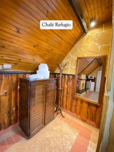 a bathroom with a mirror and a wooden wall at Mirágua Refugios Pousada in Brotas