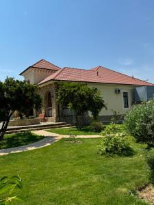 a house with a yard with grass and trees at Bilgeh Old House Villa in Baku