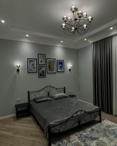 a bedroom with a large bed and a chandelier at Bilgeh Old House Villa in Baku