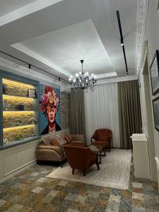 a living room with a couch and a chandelier at Bilgeh Old House Villa in Baku