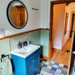 a bathroom with a sink and a mirror at Hebron Rural converted chapel in Nantglyn +14 photos