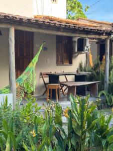 a patio of a house with a picnic table at Casa Recanto- Vila Uryah in Caraíva