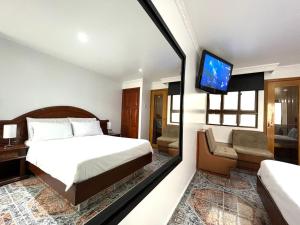 a hotel room with a bed and a tv at Lavid Hotel Kennedy in Bogotá