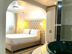 a bedroom with a large bed and a bath tub at Lavid Hotel Kennedy in Bogotá