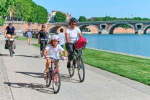 a woman and a child riding bikes down a sidewalk at Riverside Toulouse (Renaissance) in Toulouse +7 photos