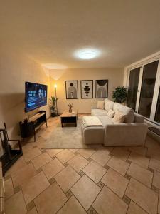 a living room with a couch and a flat screen tv at MarktQuartier Bad Schandau in Bad Schandau