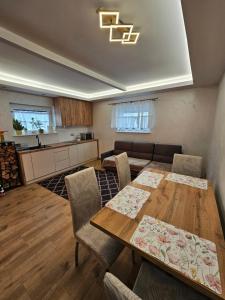 a living room with a table and a kitchen at Domek na Sosnowej in Wilków