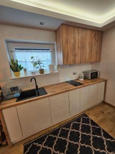 a kitchen with a sink and a counter with a window at Domek na Sosnowej in Wilków