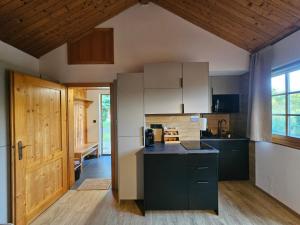 a kitchen with white cabinets and a black counter top at Tatralandia Chatka 112 in Liptovský Mikuláš