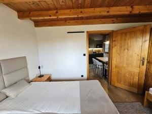 a bedroom with a large white bed and a table at Tatralandia Chatka 112 in Liptovský Mikuláš +29 photos