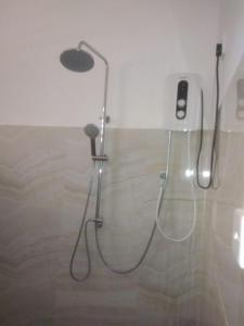 a shower in a bathroom with a phone on the wall at The Corel Waves Inn in Kalkudah