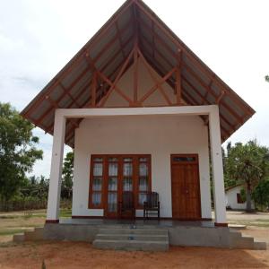a small house with a large roof at The Corel Waves Inn in Kalkudah