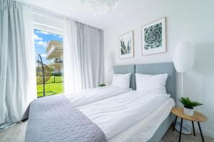 a bedroom with a large bed and a large window at ApartView - ogród, taras, winda, widok na Jeziorak, Netflix i Max, parking in Iława