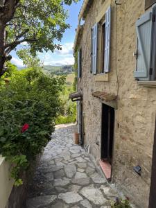 an alley in an old stone building with a window at L'écrin vert in Villelongue-dʼAude