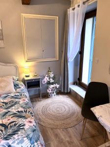 a bedroom with a bed and a table and a window at L'écrin vert in Villelongue-dʼAude