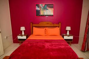 a red bedroom with a bed with orange pillows at Cozy one bedroom & Car rental apartment in Lambeau