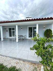 a white house with a patio with a table at Theros 2 in Xanthi