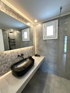 a bathroom with a black sink and a shower at Theros 2 in Xanthi +8 photos