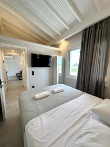 a bedroom with a large bed with two towels on it at Theros 2 in Xanthi