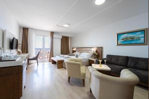 a large living room with a couch and a living room with a couch at Hotel Adrović in Sveti Stefan +18 photos