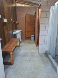 a bathroom with a sink and a toilet and a wooden table at camping los hualles in Lago Ranco